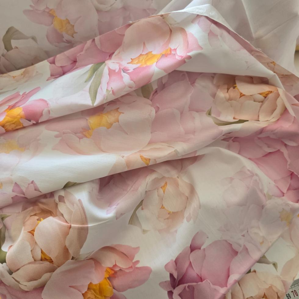 Detaliu al căderii elegante a satinului de bumbac cu motiv floral de bujori